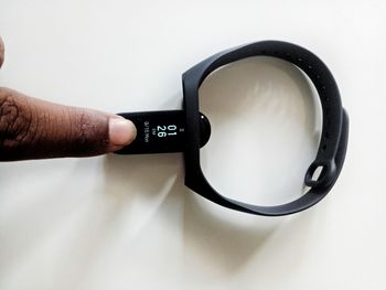 Close-up of hand holding eyeglasses against white background