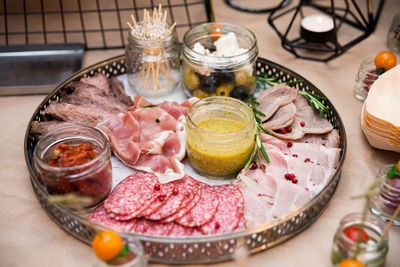 Sliced sausage, meat asorti, prosciutto and bacon with mustard sauce, sun-dried tomatoes and olives