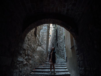 Rear view of woman standing by staircase in building