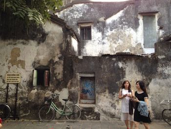 Women standing against old building