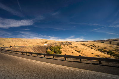 Road leading towards mountains against sky