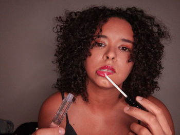 Portrait of woman making face against gray background