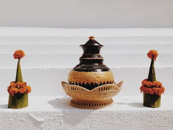 Close-up of various flowers on table against wall