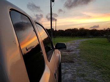Sunset sky reflects off vehicle window