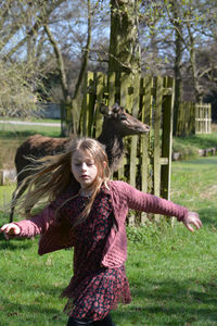 Girl standing by tree