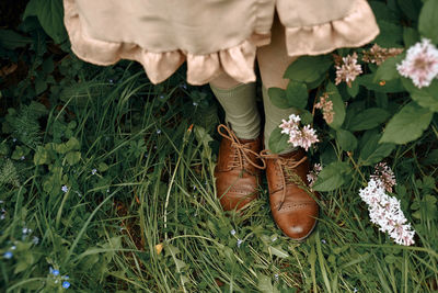 Low section of woman standing on field