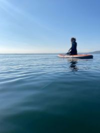 Female paddle boarding on calm sea