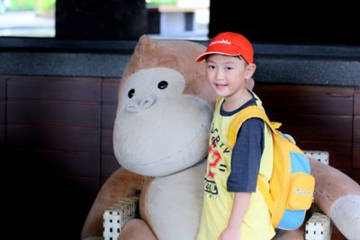 Portrait of cute boy sitting at toy