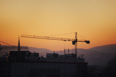 Low angle view of crane against clear sky during sunset