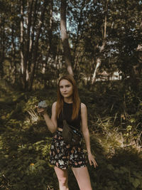 Portrait of a beautiful young woman holding tree