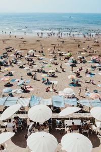 High angle view of people with parasols at beach during summer