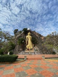 Statue of buddha against cloudy sky