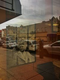 Cars on city street against sky