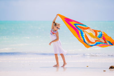 Woman standing at beach against sky