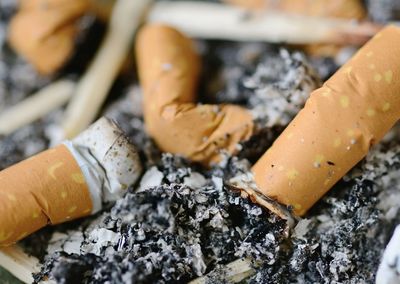 High angle view of cigarette butts and ash in tray