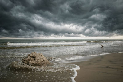 Scenic view of sea against stormy sky at the beach