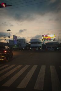 Vehicles on road at sunset