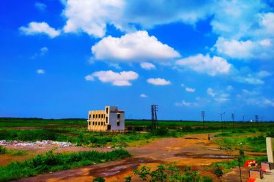 Building on field against blue sky