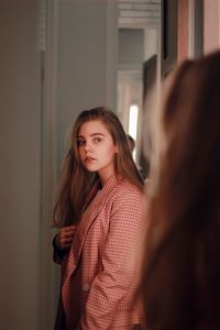 Portrait of woman standing in front of mirror