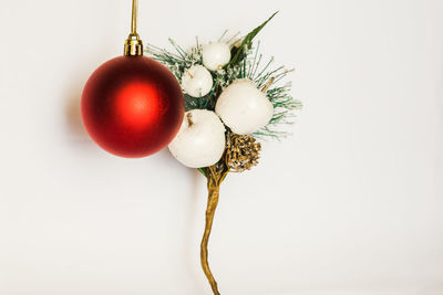 Close-up of christmas decorations hanging on white background