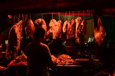 Rear view of man for sale at market stall