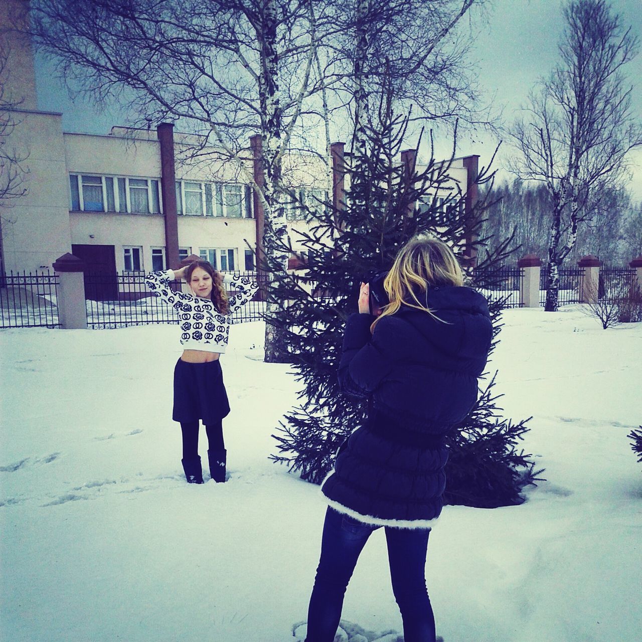 winter, snow, cold temperature, lifestyles, season, warm clothing, full length, leisure activity, weather, casual clothing, standing, bare tree, building exterior, walking, front view, person, built structure, architecture