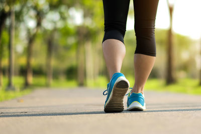 Rear view of woman walking on road