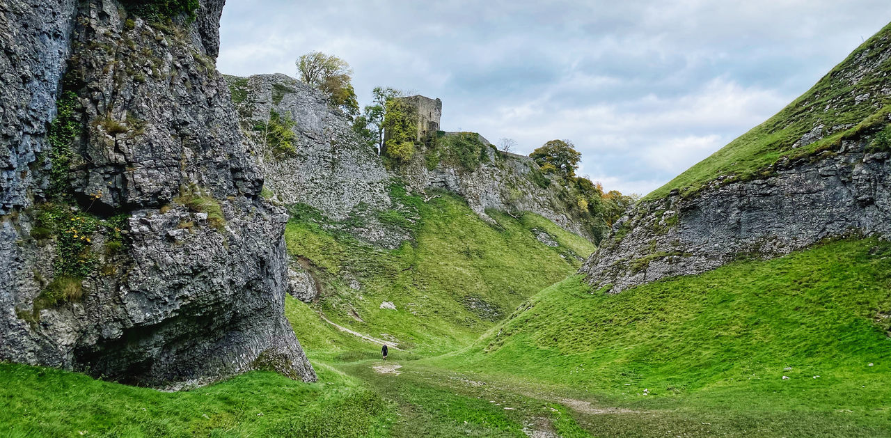 sky, plant, nature, land, cloud, environment, scenics - nature, landscape, mountain, beauty in nature, mountain range, cliff, green, grass, travel destinations, terrain, rock, travel, no people, valley, tranquility, outdoors, tree, tourism, non-urban scene, history, mountain pass, tranquil scene, architecture, day, the past, ridge, idyllic, rock formation, activity, highland, forest, ancient