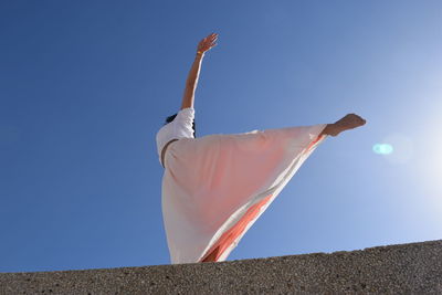 Low angle view of woman against clear sky