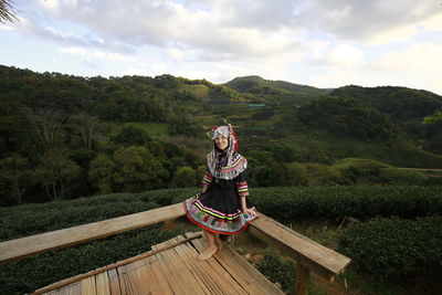 Full length of woman with umbrella against sky