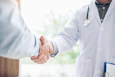 Midsection of man and woman holding hands