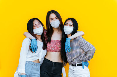 Portrait of young women against yellow background