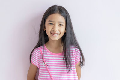 Portrait of a smiling young woman against white background