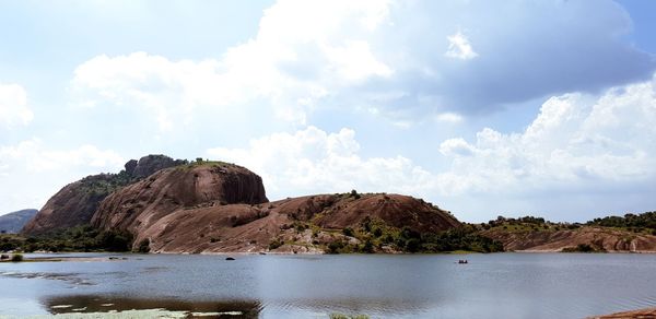 Rock formations by sea against sky