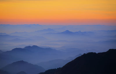 Scenic view of silhouette mountains against romantic sky