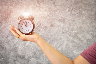 Close-up of woman hand holding clock