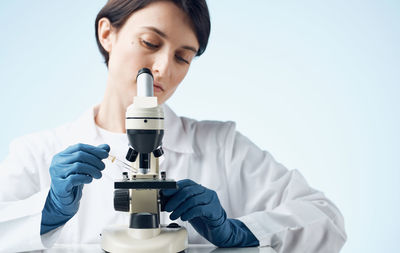 Female scientist using microscope at laboratory