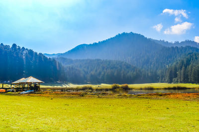 Scenic view of field and mountains against sky