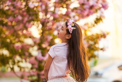 Side view of woman standing on flowering plant