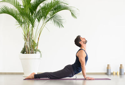 Side view of man exercising against wall