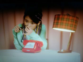 Portrait of girl holding camera at home