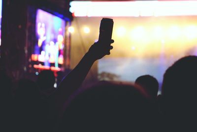 Person holding beer can in concert