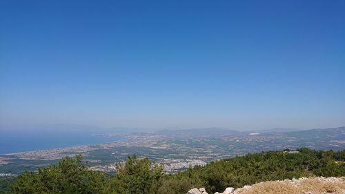 Scenic view of landscape and mountains against clear blue sky