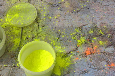 High angle view of yellow powder paint in container on footpath