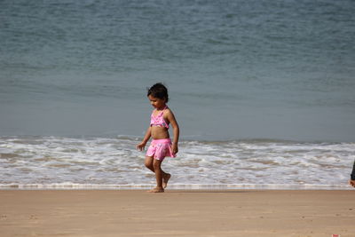 Full length of girl walking on shore at beach