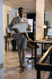 Low section of man using digital tablet while standing in office