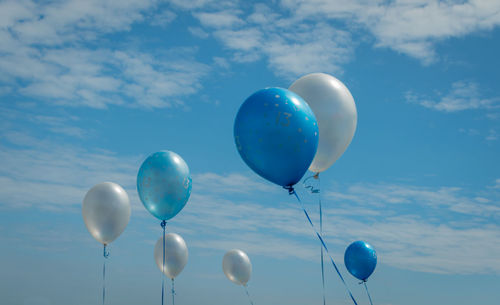 Low angle view of balloons against blue sky
