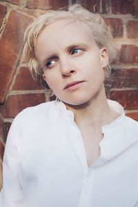 Woman looking away against wall