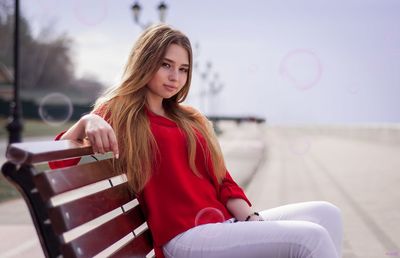 Portrait of smiling young woman sitting outdoors