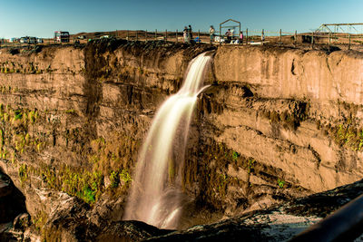 Scenic view of waterfall against sky